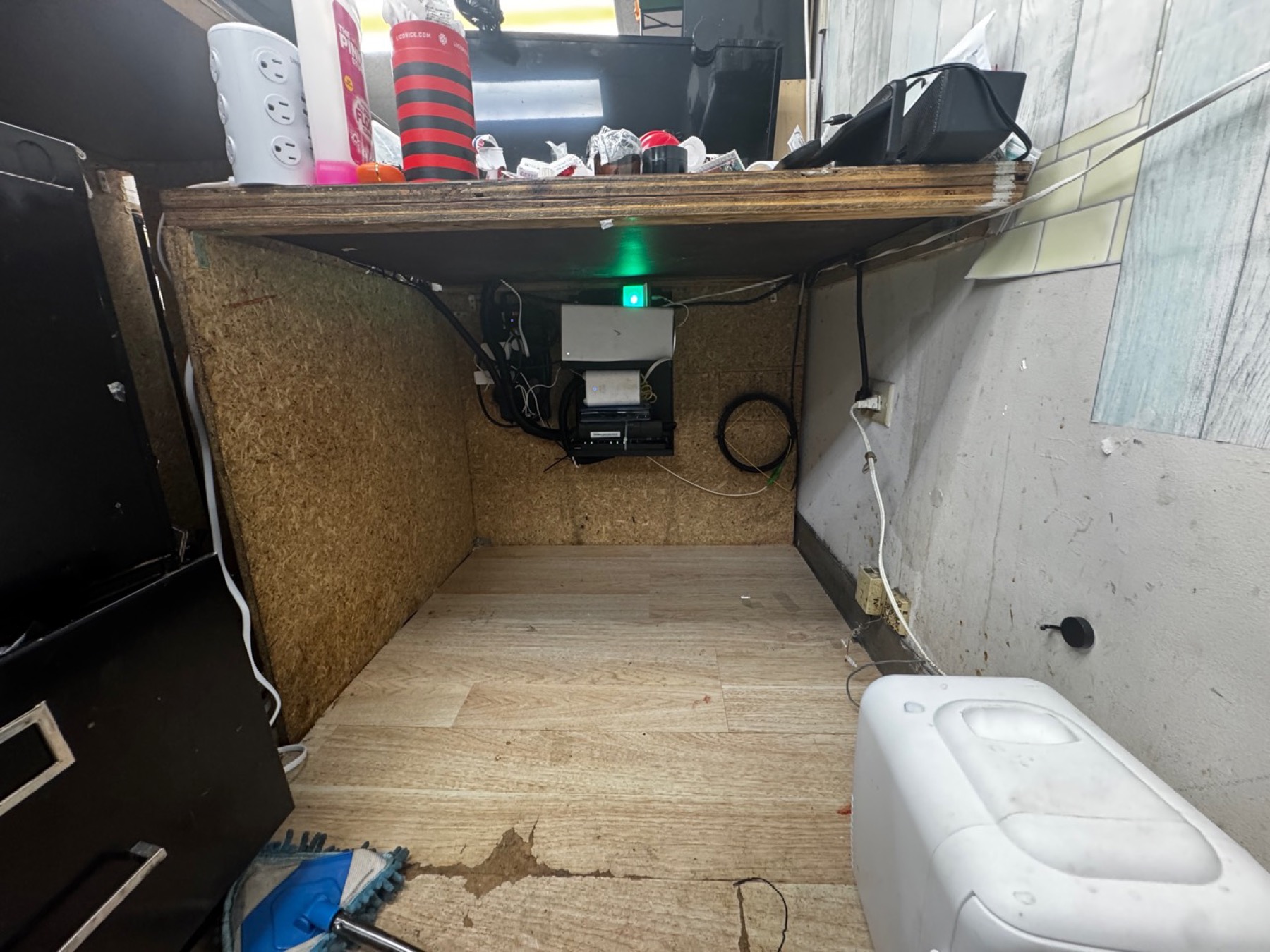 After networking cleanup at Tommy K Supplements showing a cleared workspace and organized network equipment mounted under the counter.