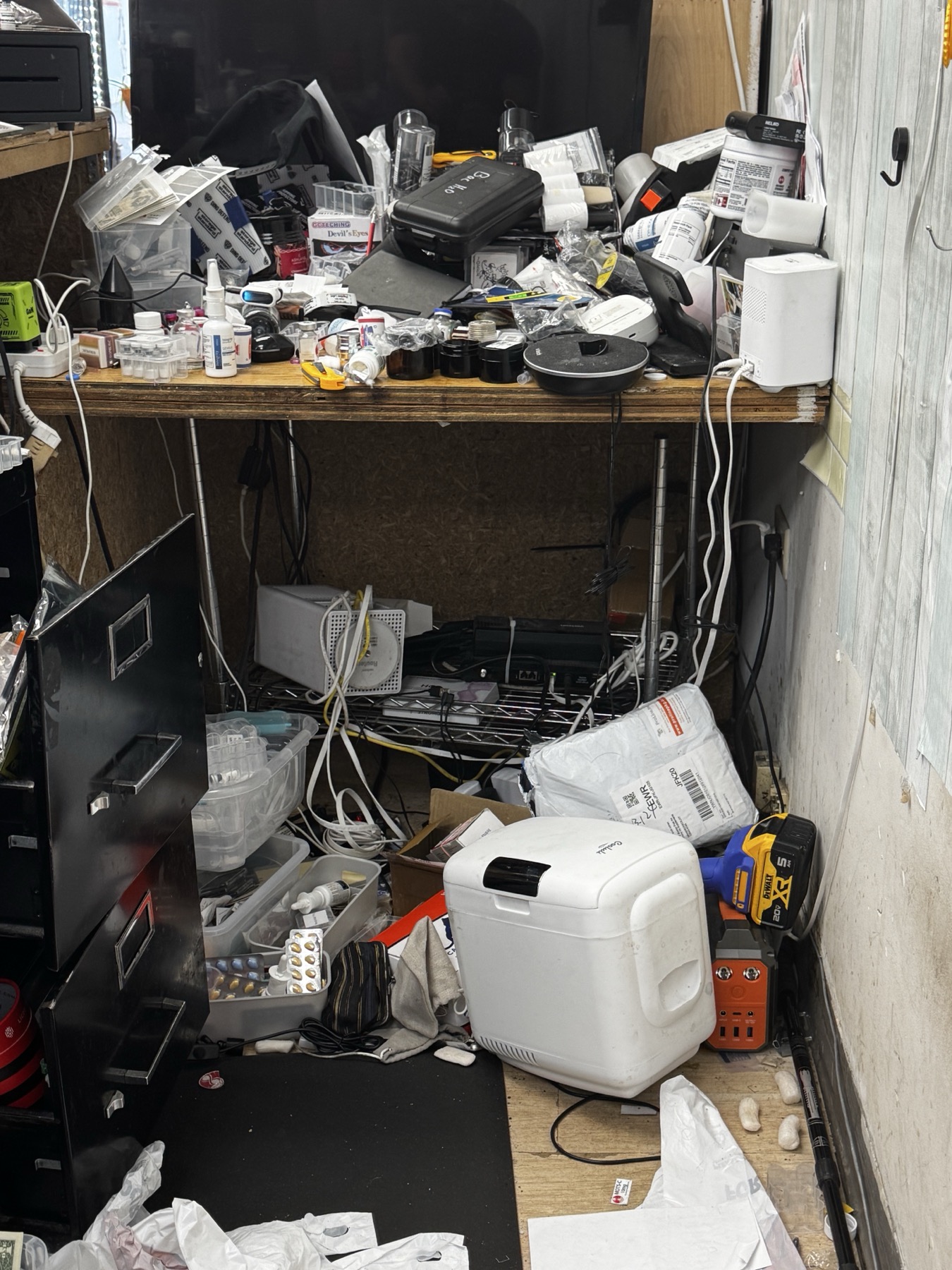 Closer before view of the Tommy K Supplements networking area with tangled cables and equipment under the counter.